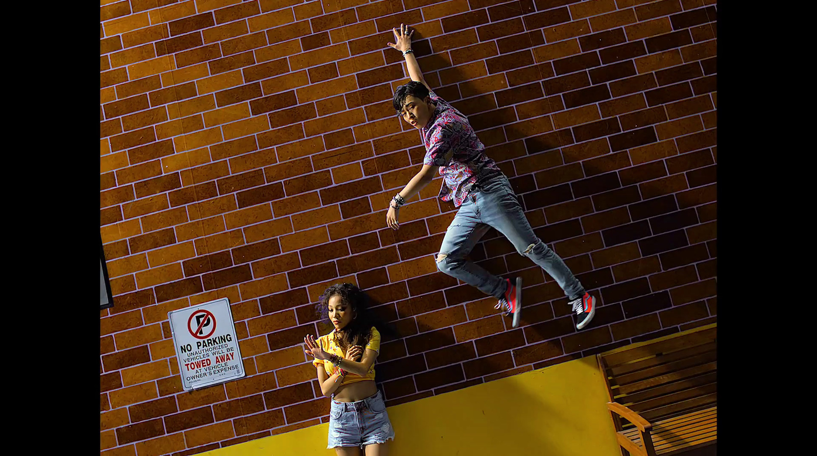 a man and a little girl standing next to a brick wall