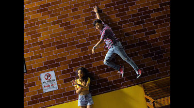 a man and a little girl standing next to a brick wall