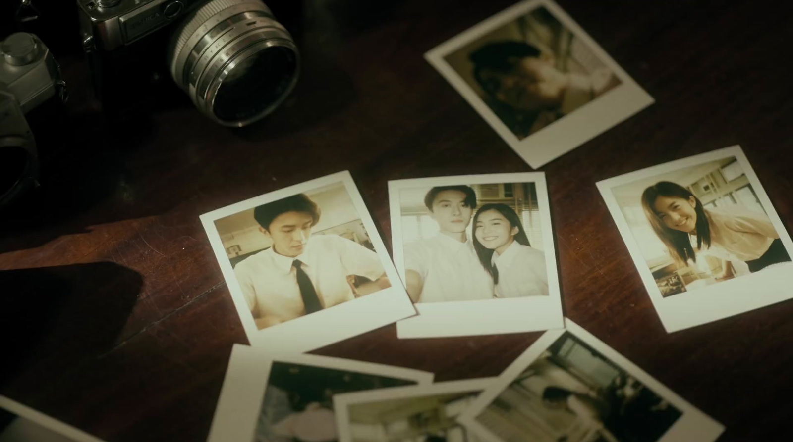 a table topped with polaroid pictures and a camera