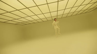 a man in a white suit standing in a room