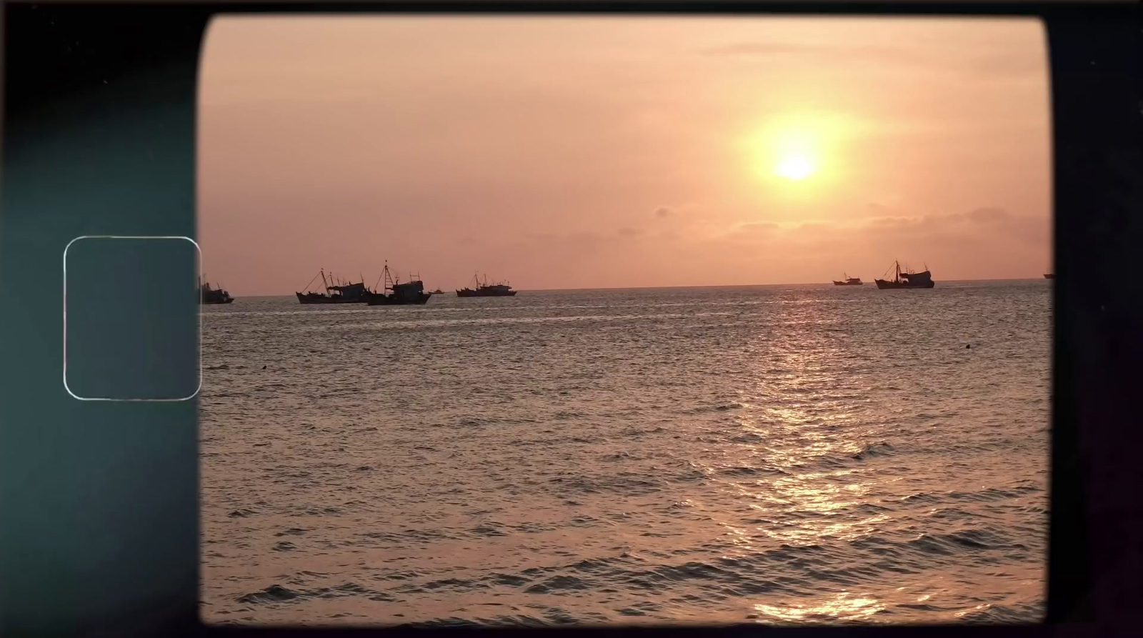 a view of boats in the ocean at sunset