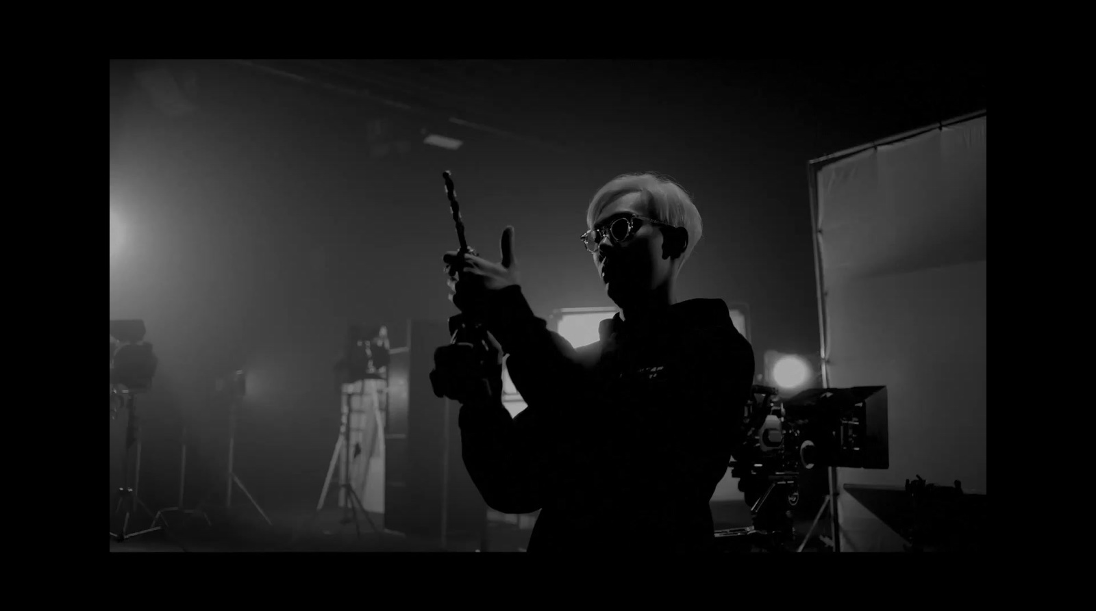 a man holding a gun in a dark room