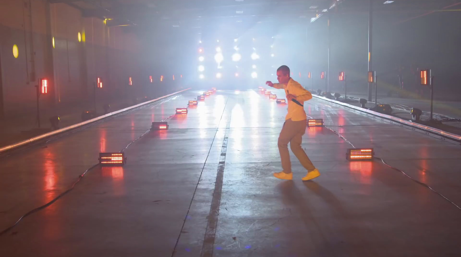 a man in a yellow shirt is dancing on a stage