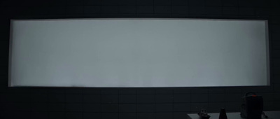 a large projection screen in a dark bathroom