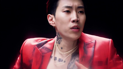 a man in a red jacket with tattoos on his chest