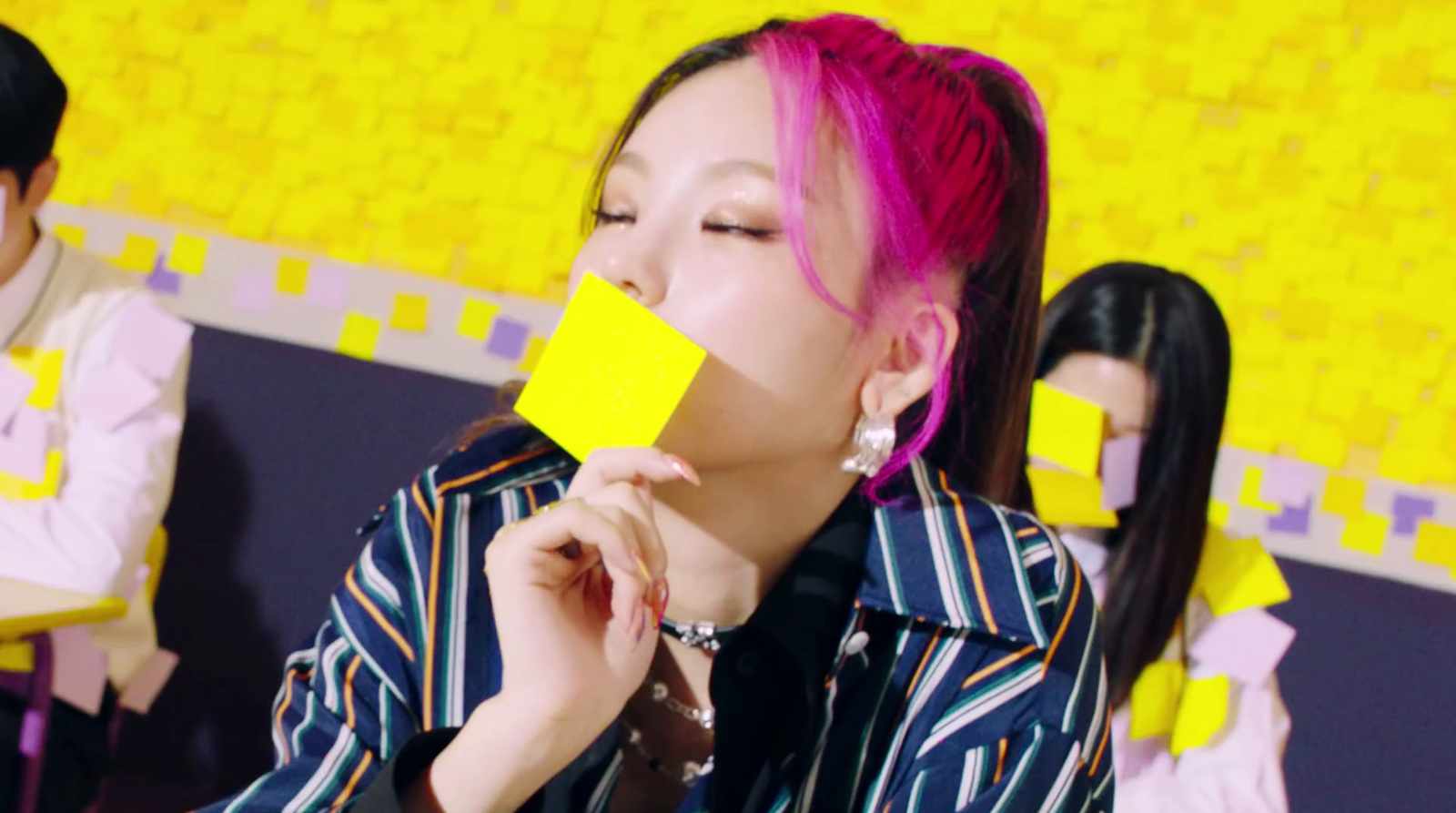 a woman with pink hair is holding a yellow piece of paper