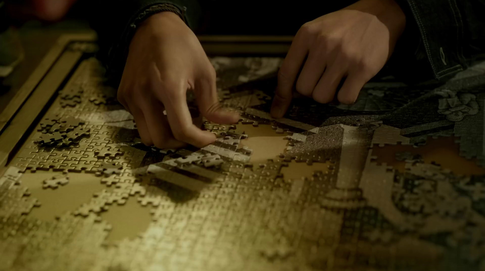 a person placing a piece of puzzle on a table