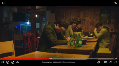 a man sitting at a table writing on a piece of paper