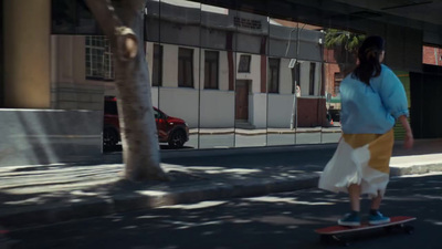 a woman riding a skateboard down a street