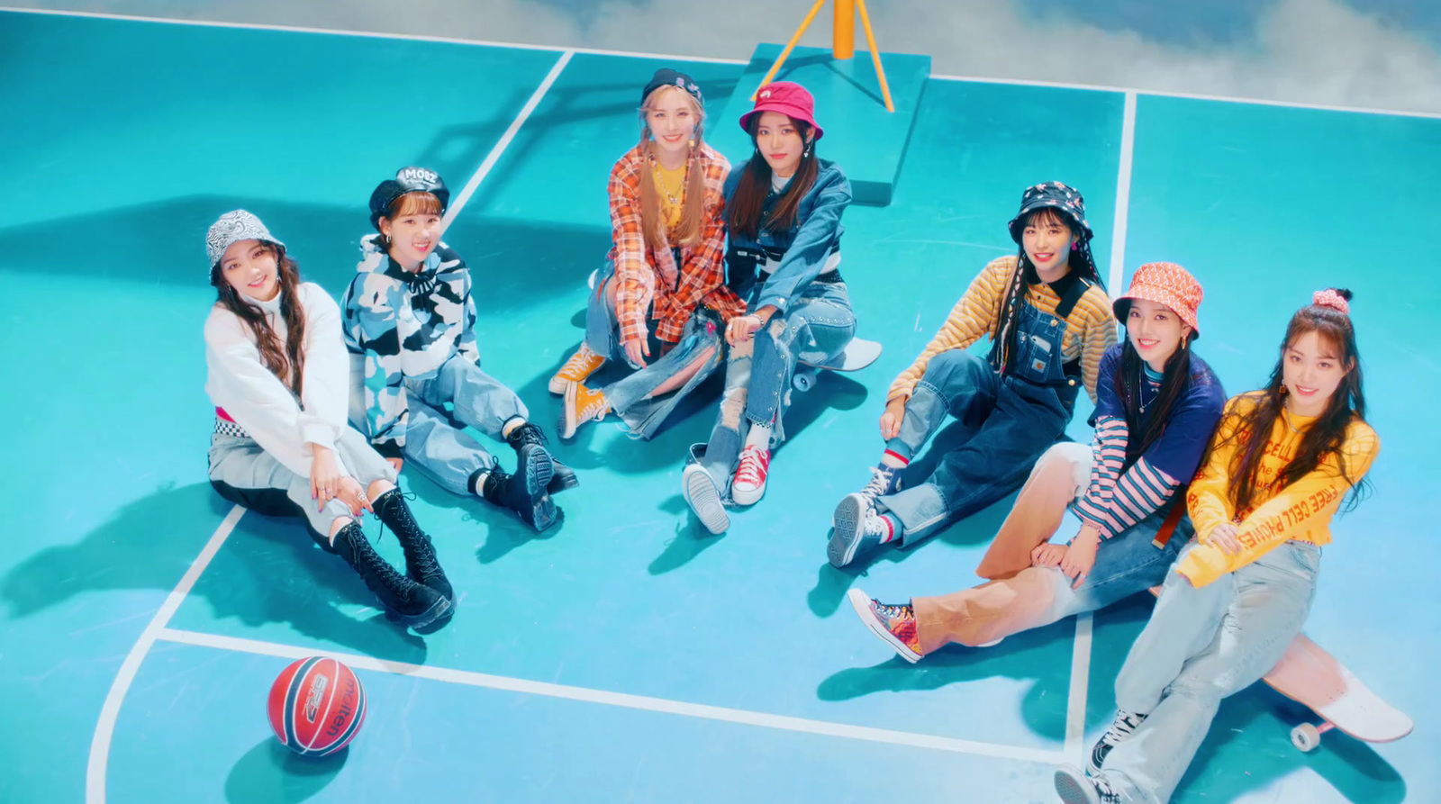 a group of young people sitting on top of a basketball court