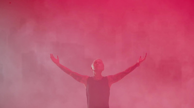 a man standing in front of a pink smoke cloud