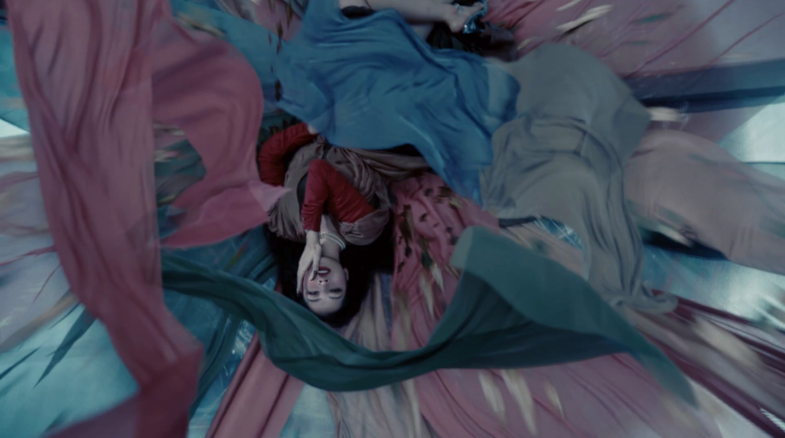 a woman laying on top of a blue and pink blanket