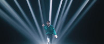 a man standing on a stage with a lot of lights behind him