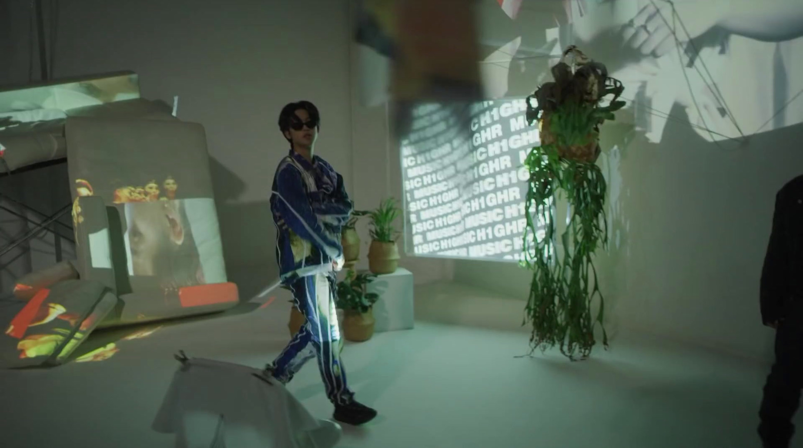 a man is walking in a room with plants