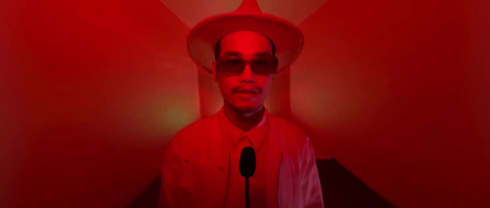 a man in a red room with a microphone