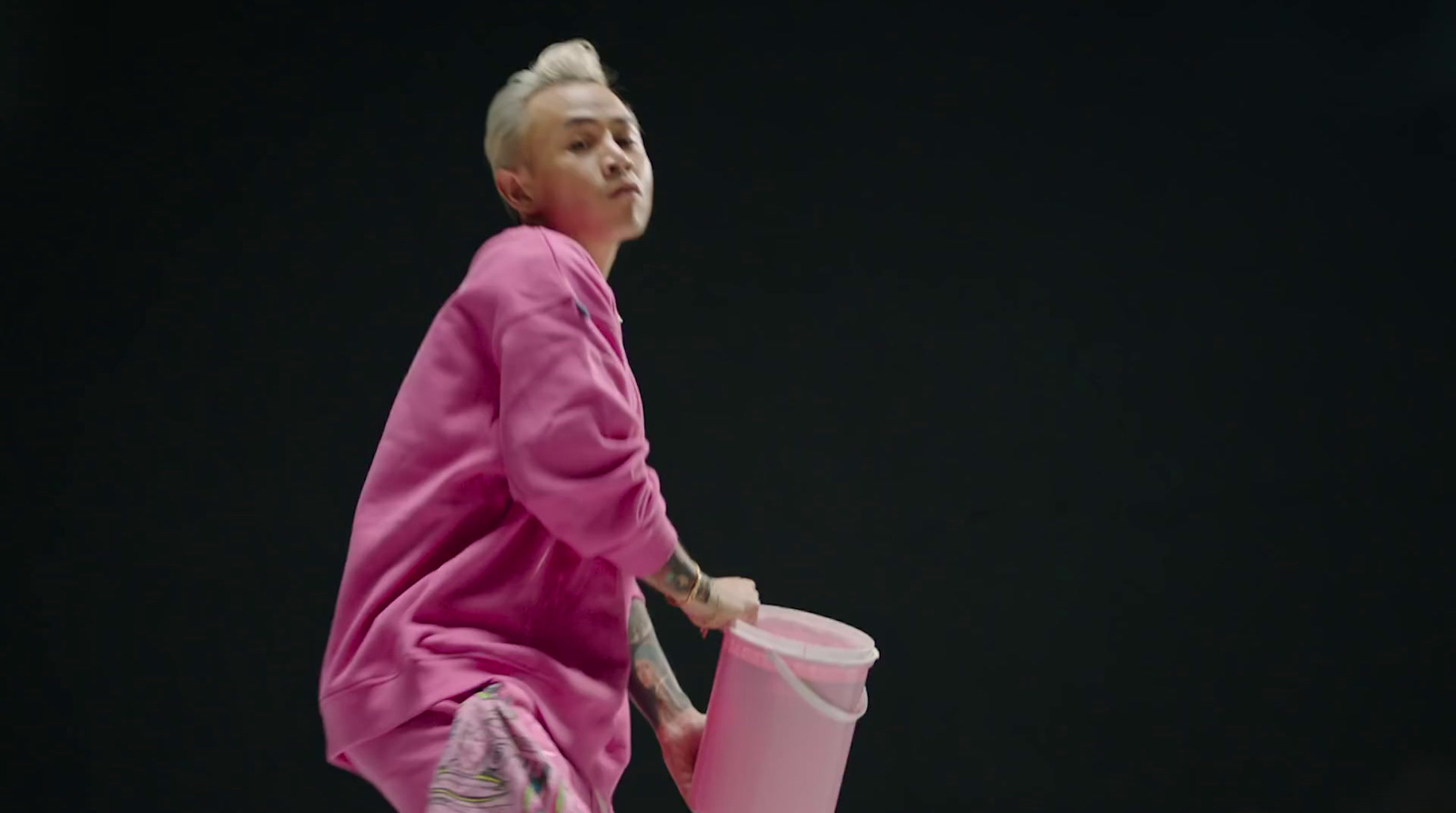 a woman in a pink outfit holding a pink cup