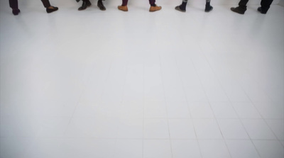 a group of people walking across a white floor