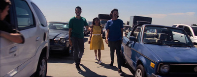 a group of people standing next to parked cars