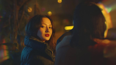 a woman standing next to a man in a dark room