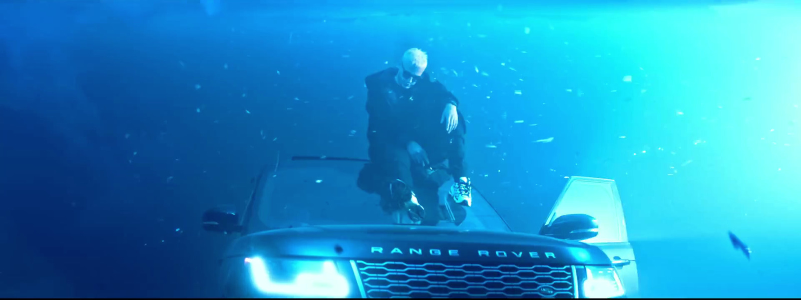 a man standing on top of a car under water