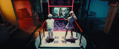 two mannequins in front of a neon display