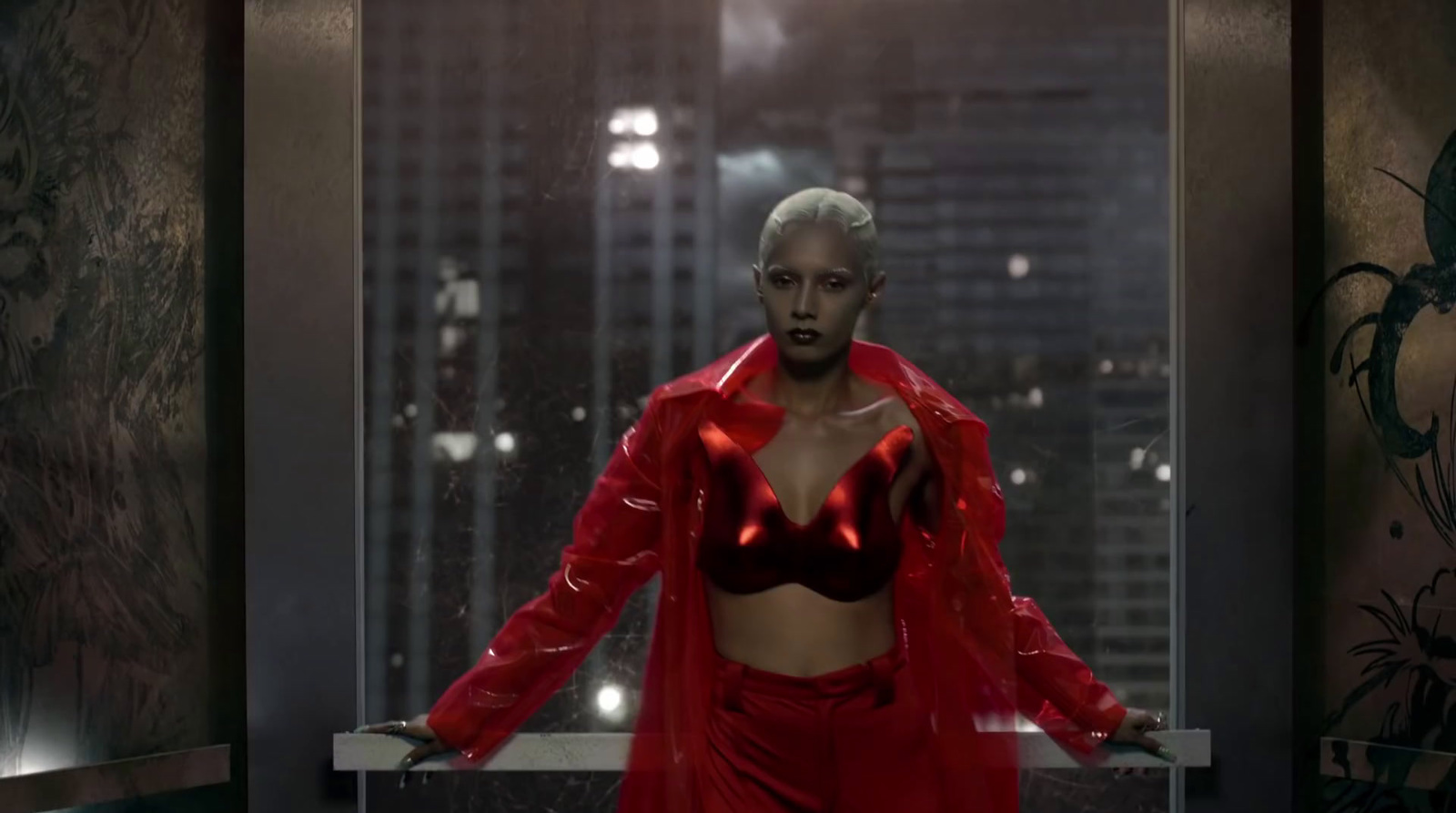 a woman in a red outfit standing in front of a window