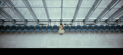 a woman standing in front of a group of blue chairs