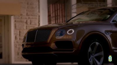 a brown car parked in front of a building