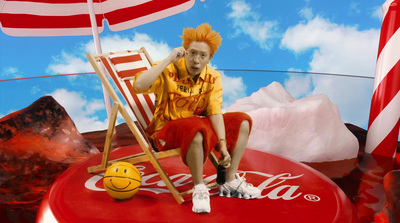 a man sitting on top of a coca cola chair