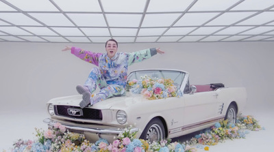 a man sitting on top of a white car