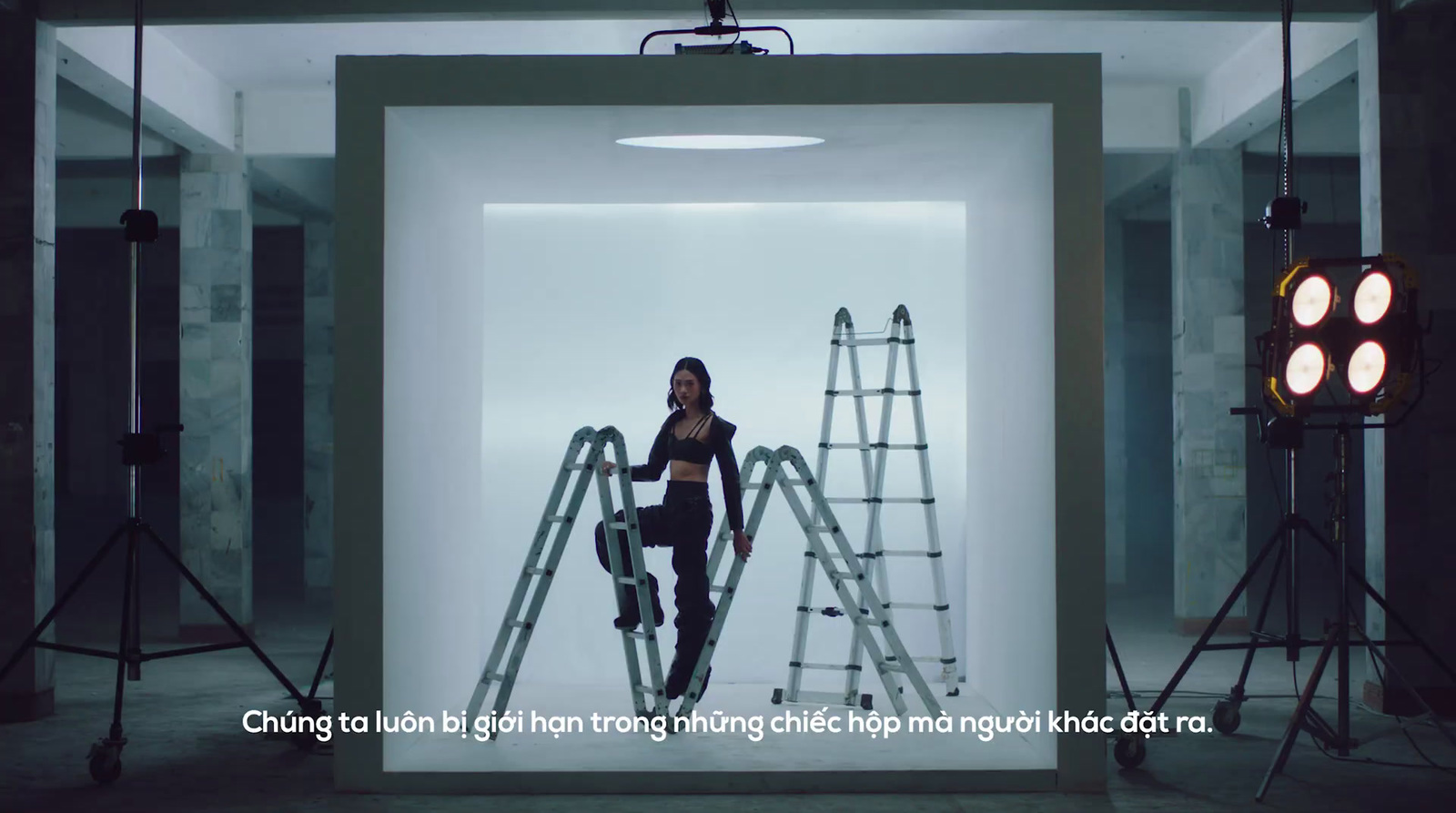 a woman standing on a ladder in a room