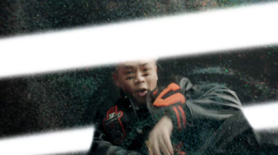 a young man sitting on the ground in front of a window