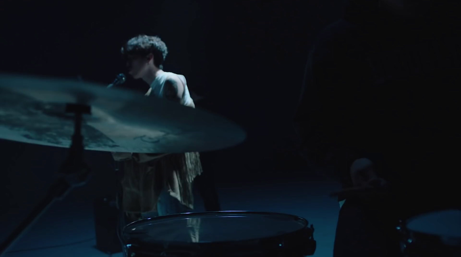 a man playing drums in a dark room