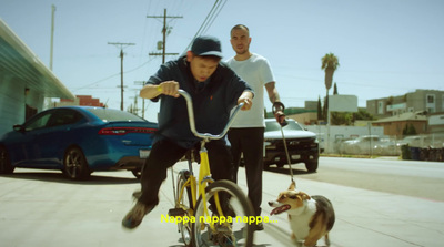 a man riding a bike next to a dog on a leash