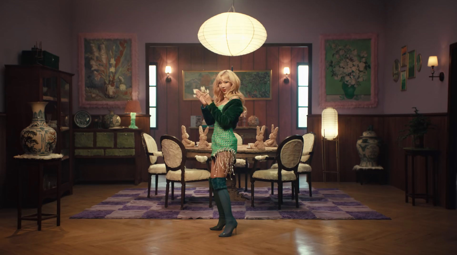 a woman in a green dress standing in a dining room