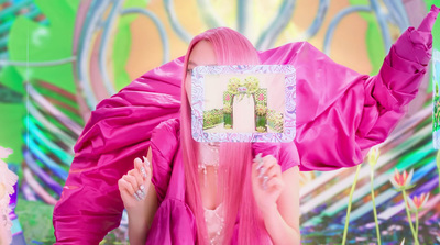 a woman with pink hair holding a picture of herself