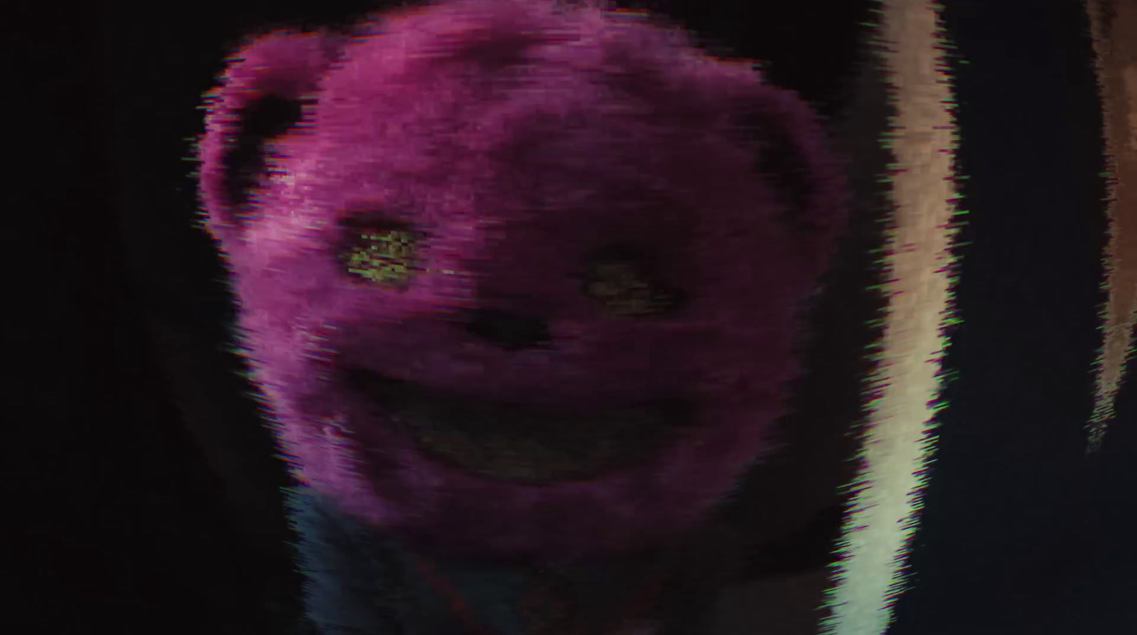 a purple stuffed animal with a smile on its face