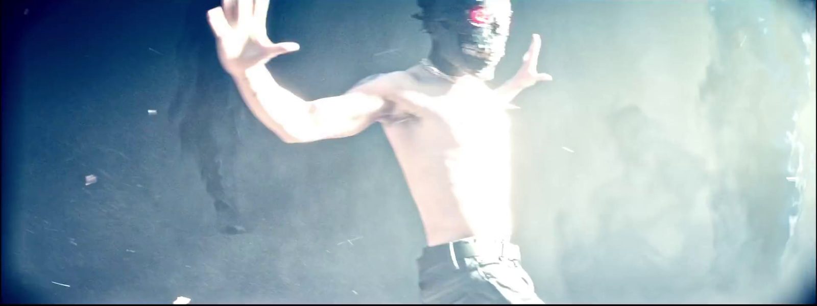 a shirtless man with his hands in the air