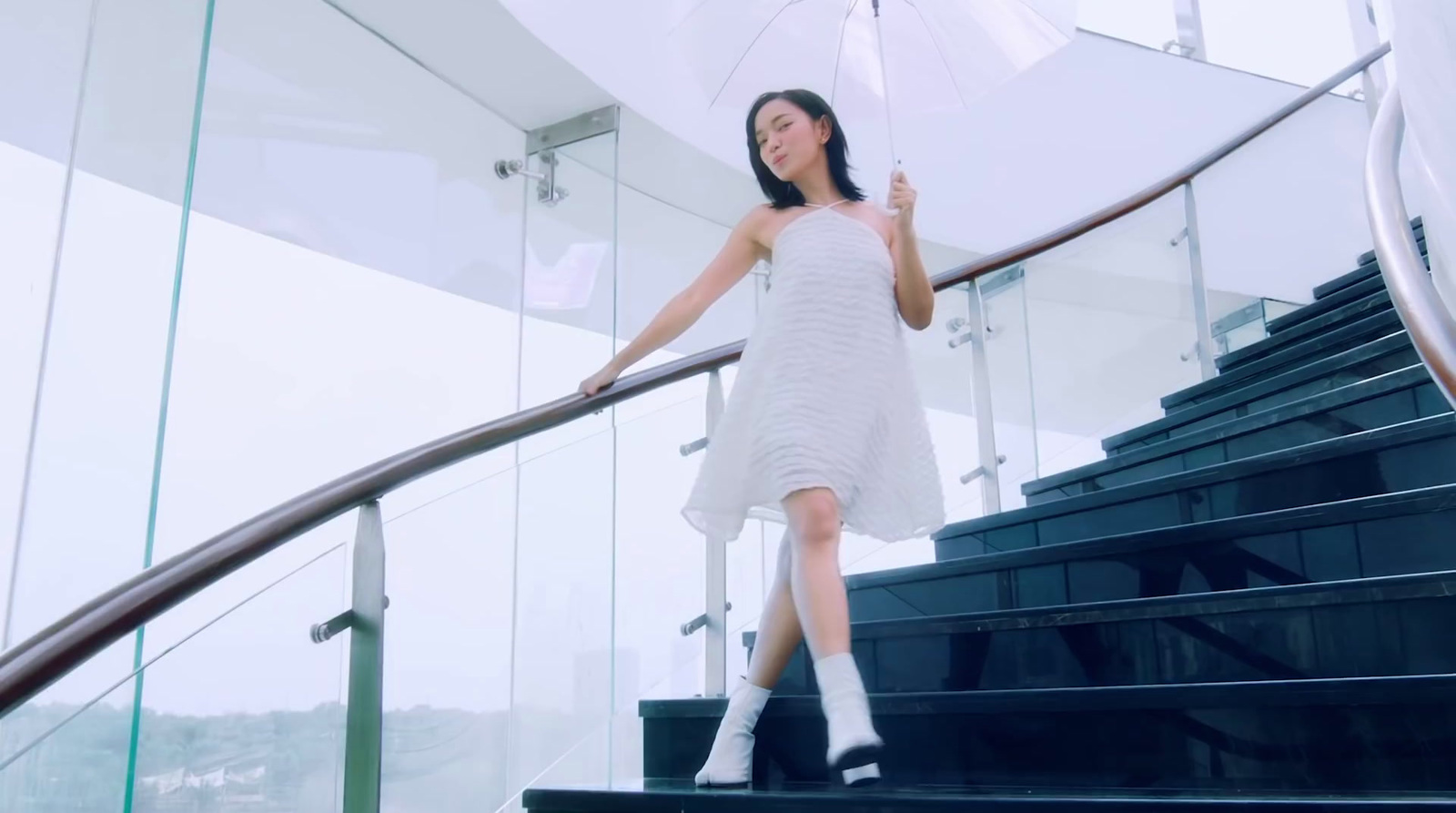 a woman in a white dress holding an umbrella