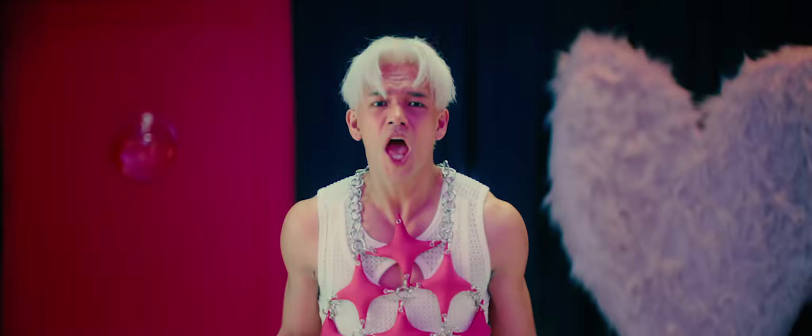 a man with white hair wearing a pink shirt