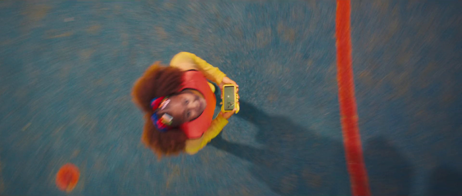 a child riding a toy car on a blue surface