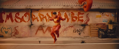 a woman is dancing in front of a graffiti covered wall