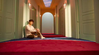 a person sitting on a red carpet in a hallway