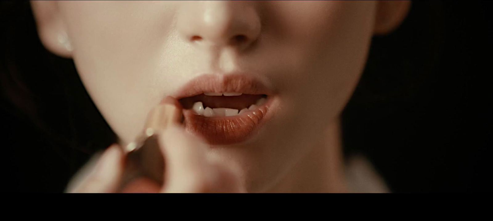 a woman brushing her teeth with a toothbrush