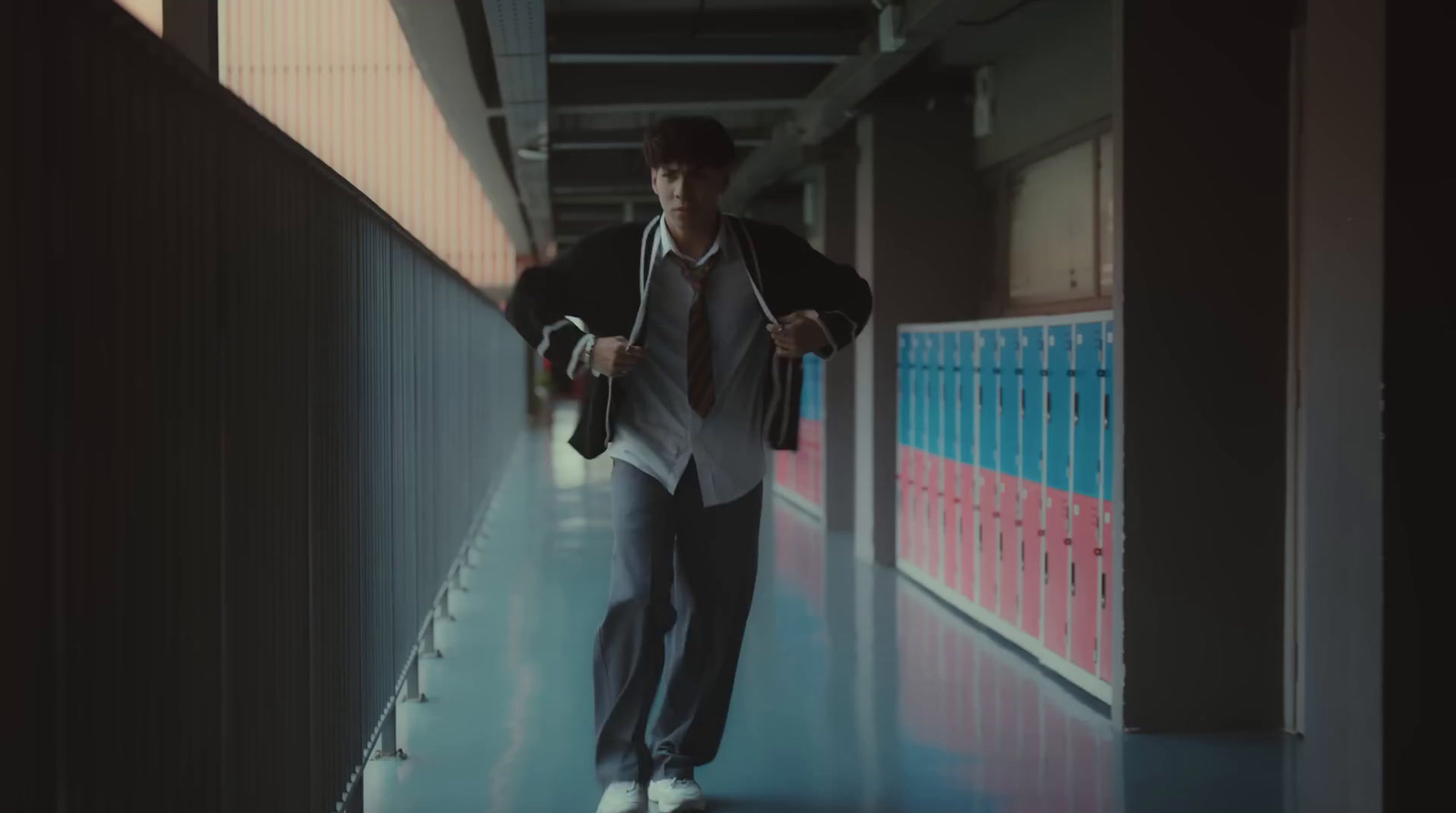 a man in a suit and tie walking down a hallway