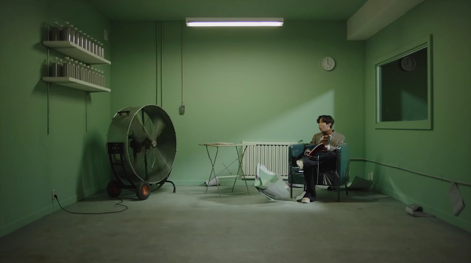 a man sitting in a room with a fan