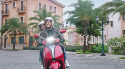 a man and a woman riding on the back of a red motorcycle