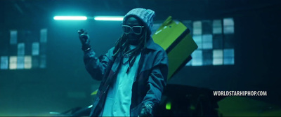 a man with dreadlocks standing in front of a car