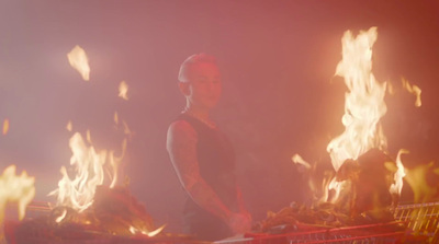 a man standing next to a shopping cart on fire