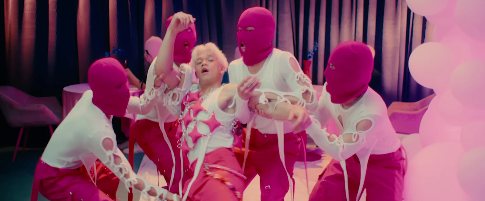 a group of women in pink and white outfits